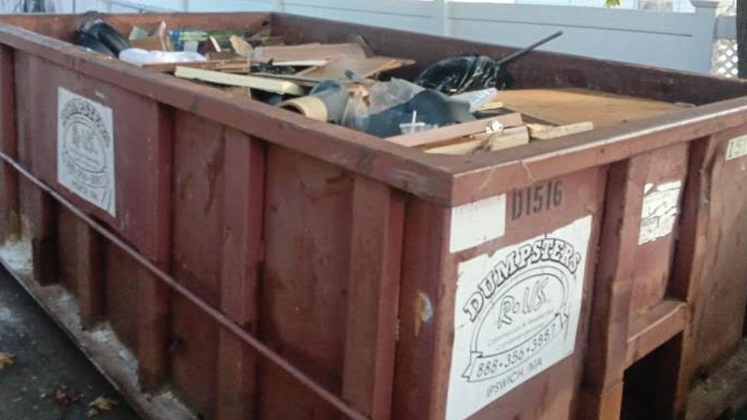 15-yard roll-off dumpster parked in a residential driveway for a basement cleanout in Lowell MA