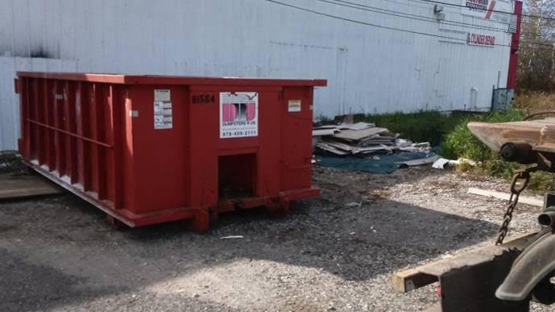 15-yard roll-off dumpster rental placed outside a commercial warehouse in Plaistow NH